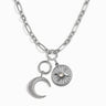 The Storm Before the Calm Charm Necklace by Awe Inspired is a silver chain adorned with two exquisite charms: a crescent moon encrusted with sparkling crystals and a round medallion showcasing a sun design centered around a pearl-like stone. Capturing the essence of the divine feminine, this piece evokes the mystique of a Triple Moon pendant.