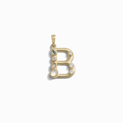 The Gemstone Initial Pendant by Awe Inspired, in the shape of the letter "B," is beautifully embellished with bezel set gemstones, making it a stunning piece of personalized jewelry.