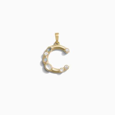 Awe Inspired's Gemstone Initial Pendant features a crescent moon adorned with bezel set gemstones, beautifully showcased on a plain white background.