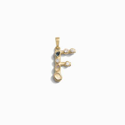 The Gemstone Initial Pendant by Awe Inspired is a gold pendant in the shape of the letter 'F,' adorned with bezel set gemstones, offering a touch of personalized jewelry elegance.