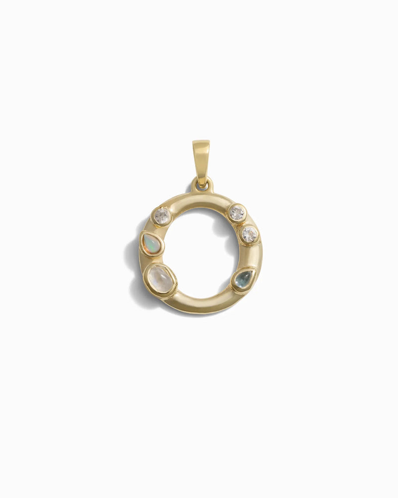 The Gemstone Initial Pendant by Awe Inspired is a stunning gold circular piece that features three small opal stones, two small diamonds, and one larger diamond arranged around the ring in a bezel setting. This exquisite pendant is ideal for those who appreciate personalized jewelry.