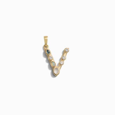 The Gemstone Initial Pendant by Awe Inspired is a gold letter 'V' pendant adorned with small bezel-set gemstones, perfect for those who love personalized jewelry.