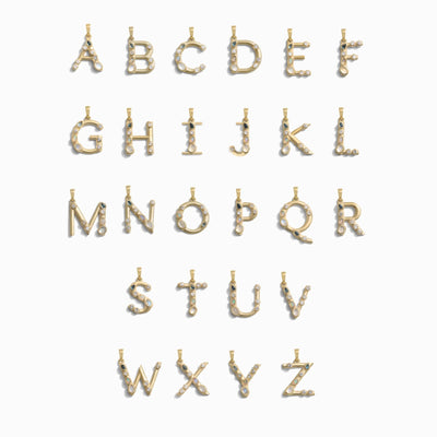 The Gold Gemstone Initial Necklace by Awe Inspired features gold alphabet pendants adorned with bezel set gemstones arranged in three rows, displaying the letters A to Z.