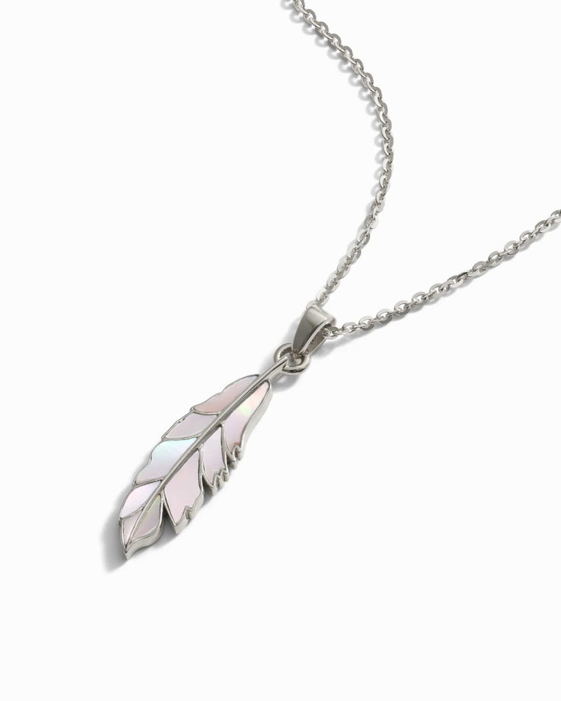 Awe Inspired's Mother of Pearl Feather Amulet is a silver necklace featuring a delicate pendant shaped like a feather with iridescent detailing, reminiscent of Athena's power, suspended from a fine chain.