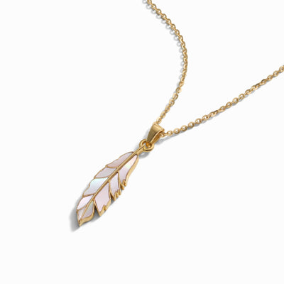 The Mother of Pearl Feather Amulet by Awe Inspired is a gold chain necklace featuring a pendant shaped like a feather with iridescent inlay on a white background, designed to invoke Athena's power.