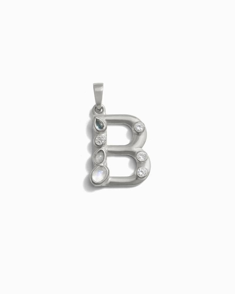 Awe Inspired's Gemstone Initial Pendant features a silver "B" design adorned with bezel set clear and grey gemstones against a white background—perfect for personalized jewelry enthusiasts.