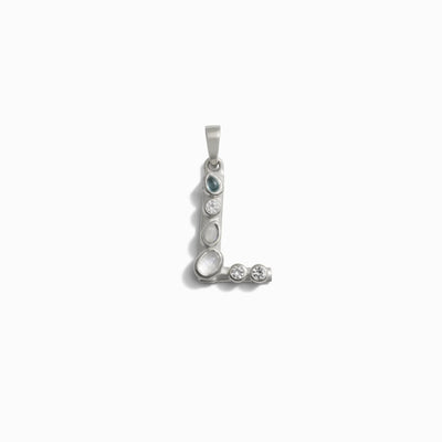 The Gemstone Initial Pendant by Awe Inspired features a silver pendant shaped like the letter "L," adorned with bezel set gemstones along its form, resting elegantly against a white background. This exquisite piece of personalized jewelry is an ideal choice for those who cherish initial charms.