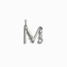 The Gemstone Initial Pendant by Awe Inspired is a stunning silver piece shaped like the letter "M," adorned with five bezel set gemstones of varying sizes and shapes, making it a perfect piece of personalized jewelry.