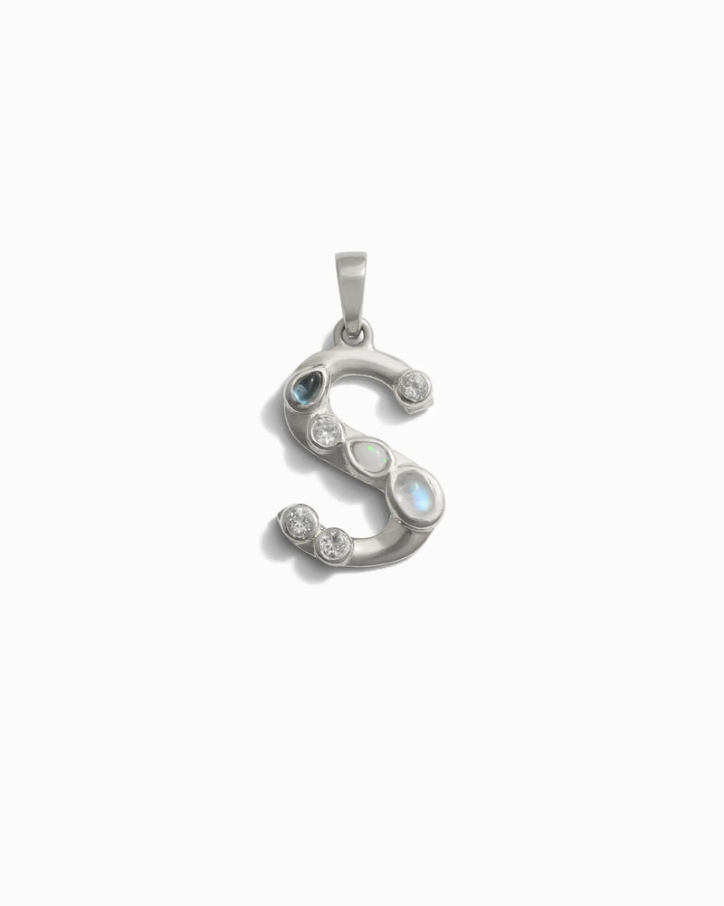 Introducing the Gemstone Initial Pendant by Awe Inspired: a sophisticated silver pendant in the shape of the letter "S," embellished with an array of small bezel-set gemstones, perfect for adding a touch of personalized jewelry elegance.
