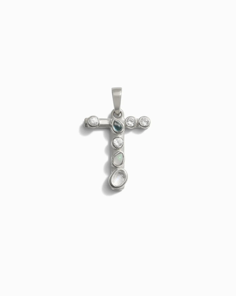The Gemstone Initial Pendant by Awe Inspired features a cross-shaped design adorned with a blend of round and oval stones, all bezel set in a refined silver frame.