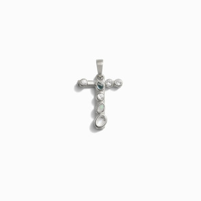 The Gemstone Initial Pendant by Awe Inspired features a cross-shaped design adorned with a blend of round and oval stones, all bezel set in a refined silver frame.