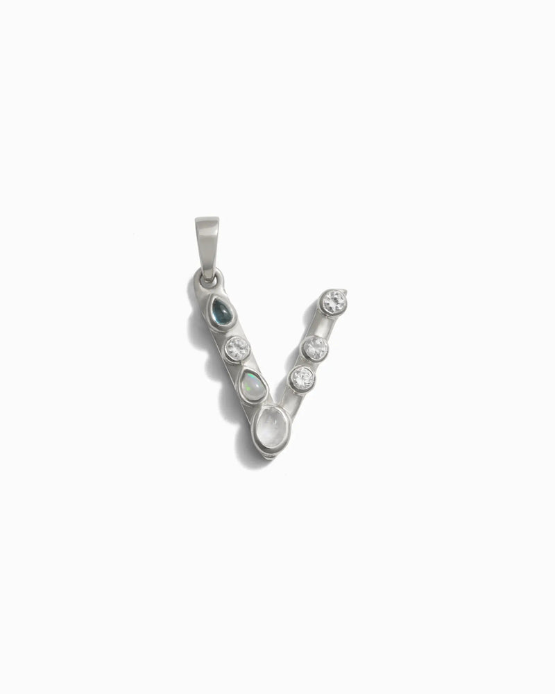 The Awe Inspired Gemstone Initial Pendant is a silver "V" shaped pendant adorned with multiple bezel-set round gemstones, ideal for those who love personalized jewelry.