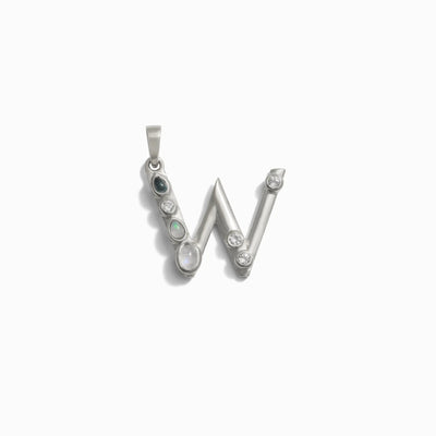 The Gemstone Initial Pendant by Awe Inspired is a silver pendant in the shape of the letter "W," adorned with bezel-set gemstones, including opals and what appear to be diamonds, set along its frame. This piece stands out as a personalized jewelry item perfect for those who love initial charms with a touch of elegance.