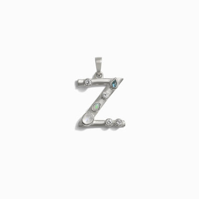 The Gemstone Initial Pendant from Awe Inspired is a stunning piece of personalized jewelry, featuring a silver pendant shaped like the letter 'Z' and adorned with bezel-set gemstones, including pearl and aquamarine.